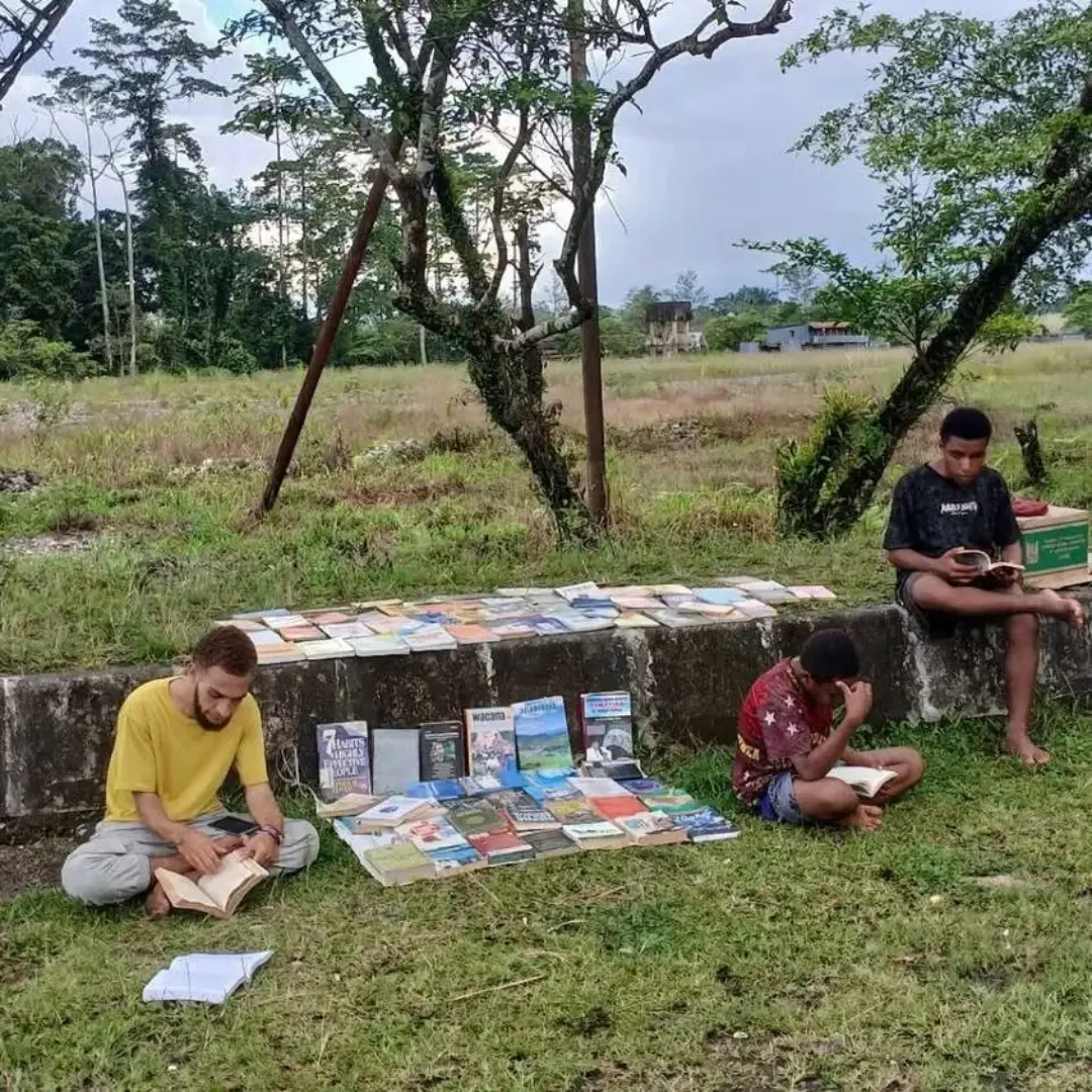 Suasana membaca yang tenang di ruang terbuka.